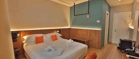 Una habitación de hotel con cama, escritorio, silla, armario y puerta.