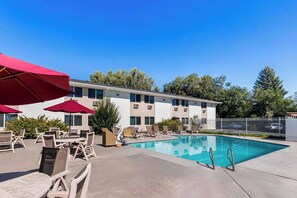 A hotel with a swimming pool, outdoor seating, and a fenced area. - Econo Lodge Idaho Falls, ID (Idaho Falls)