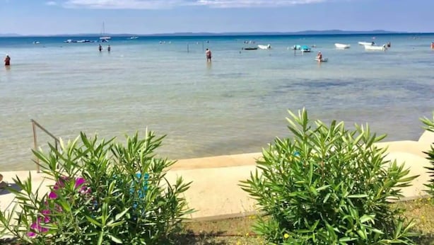 A beach with clear water, boats, and people. - Villa with amazing sea view (Priv)