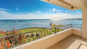 A balcony with a view of a calm sea and distant shoreline. - Villa with amazing sea view (Priv)