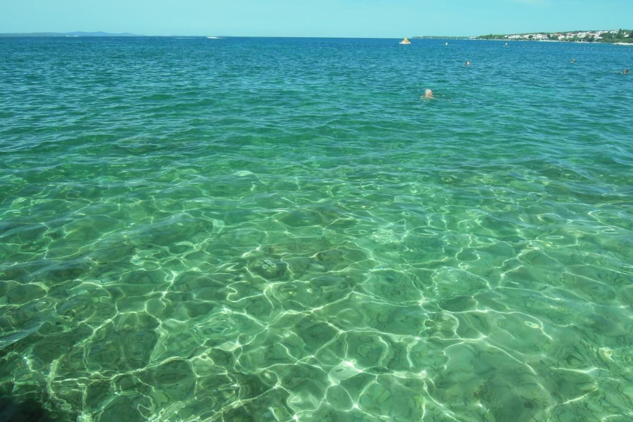 Eau de mer d’un bleu turquoise limpide, où l’on peut distinguer des motifs sous-marins.