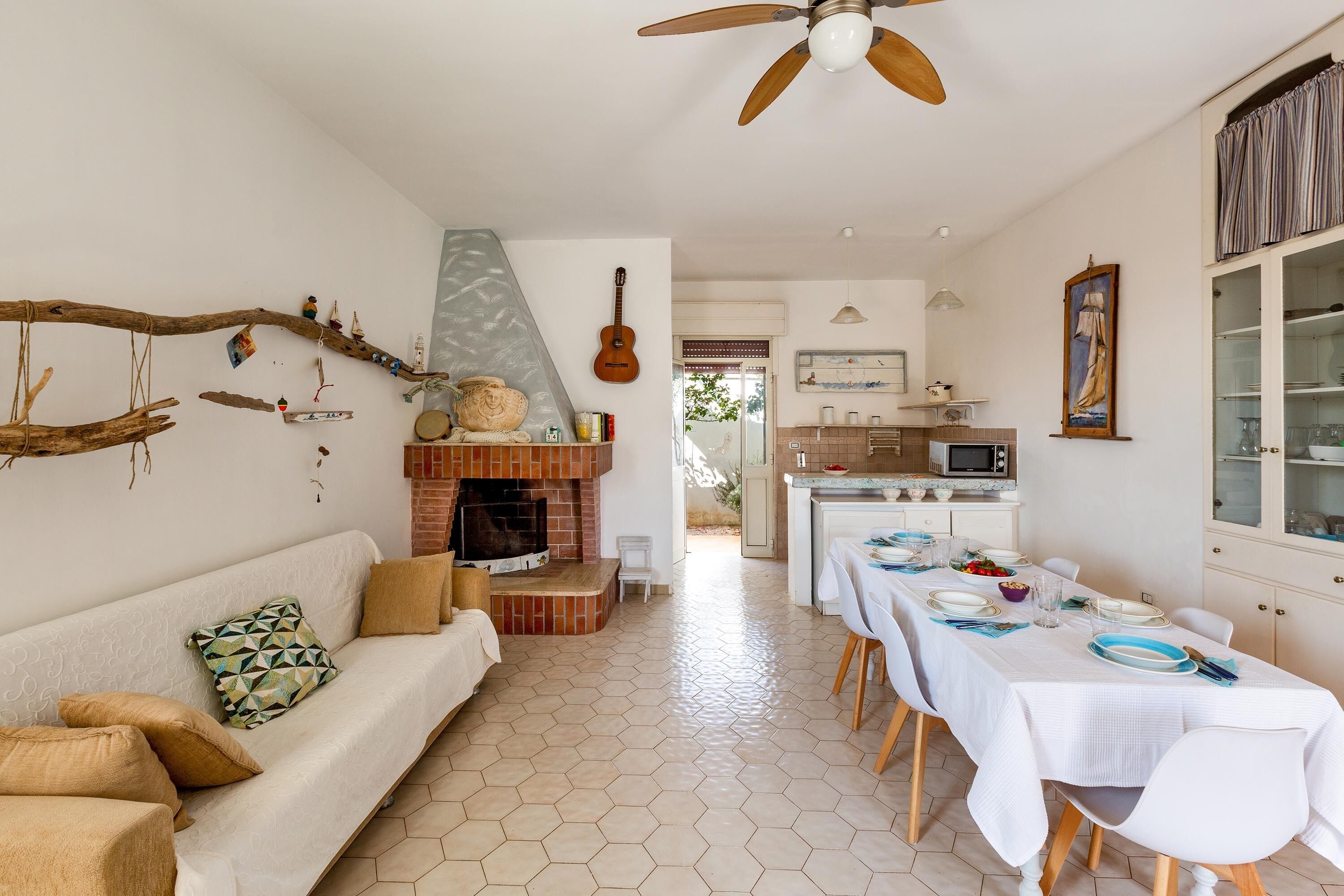 A cozy living area with a sofa, a fireplace, and a dining table set for a meal.