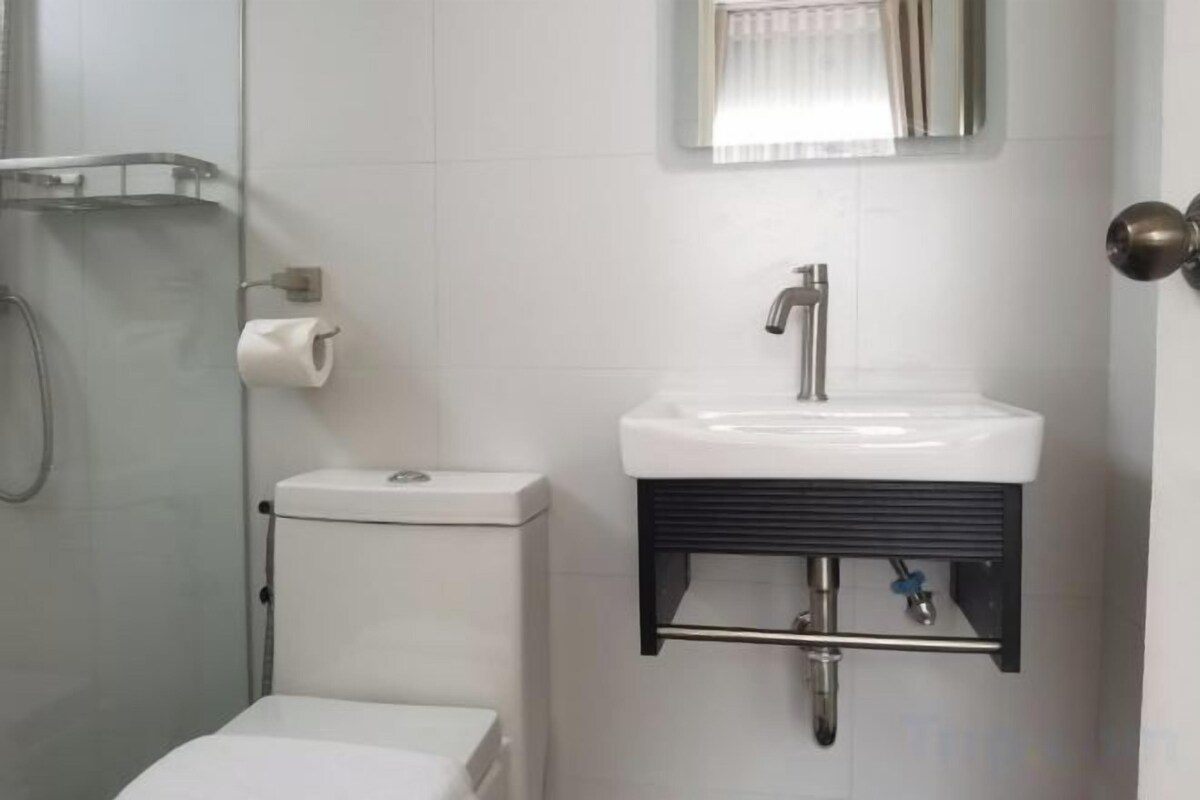 Un baño con inodoro, lavamanos y ducha.