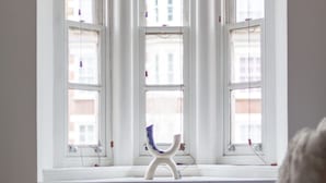 A room with a large window, a white radiator, and a white chair. - 3 Bed Apartment in St John’s Wood (London)
