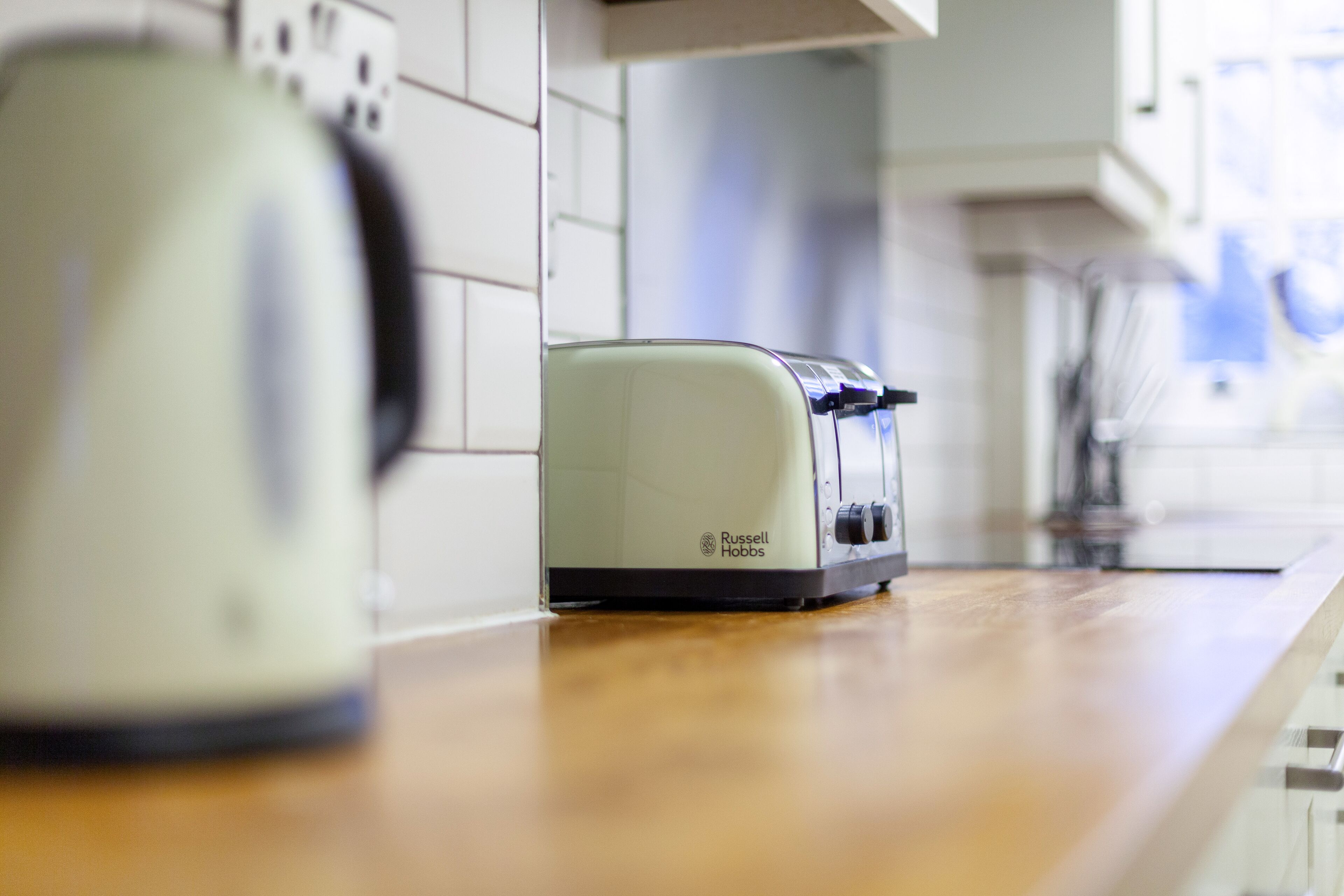 Een keuken met een broodrooster en een waterkoker op het aanrecht.