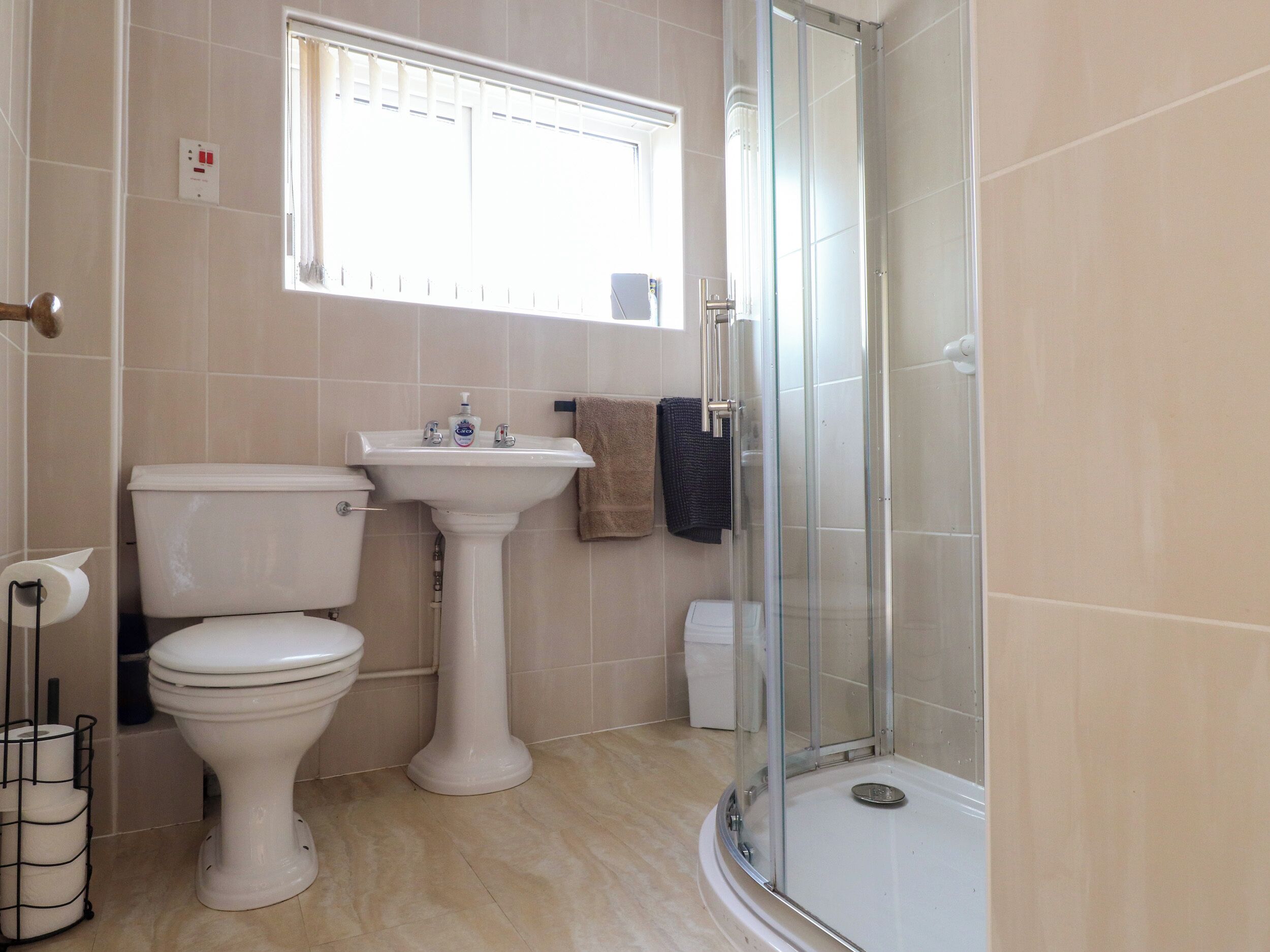 A bathroom with a toilet, sink, and glass-enclosed shower.