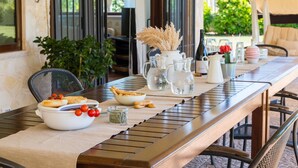 A dining table with a variety of dishes, including a bowl of bread, a pitcher, and a vase with dried flowers. - 3676 Villa Enò by Perle di Puglia (Noci)