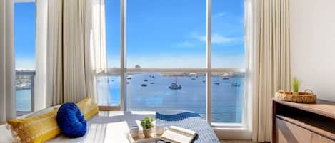 Una habitación con un ventanal que ofrece vistas de barcos en el agua.