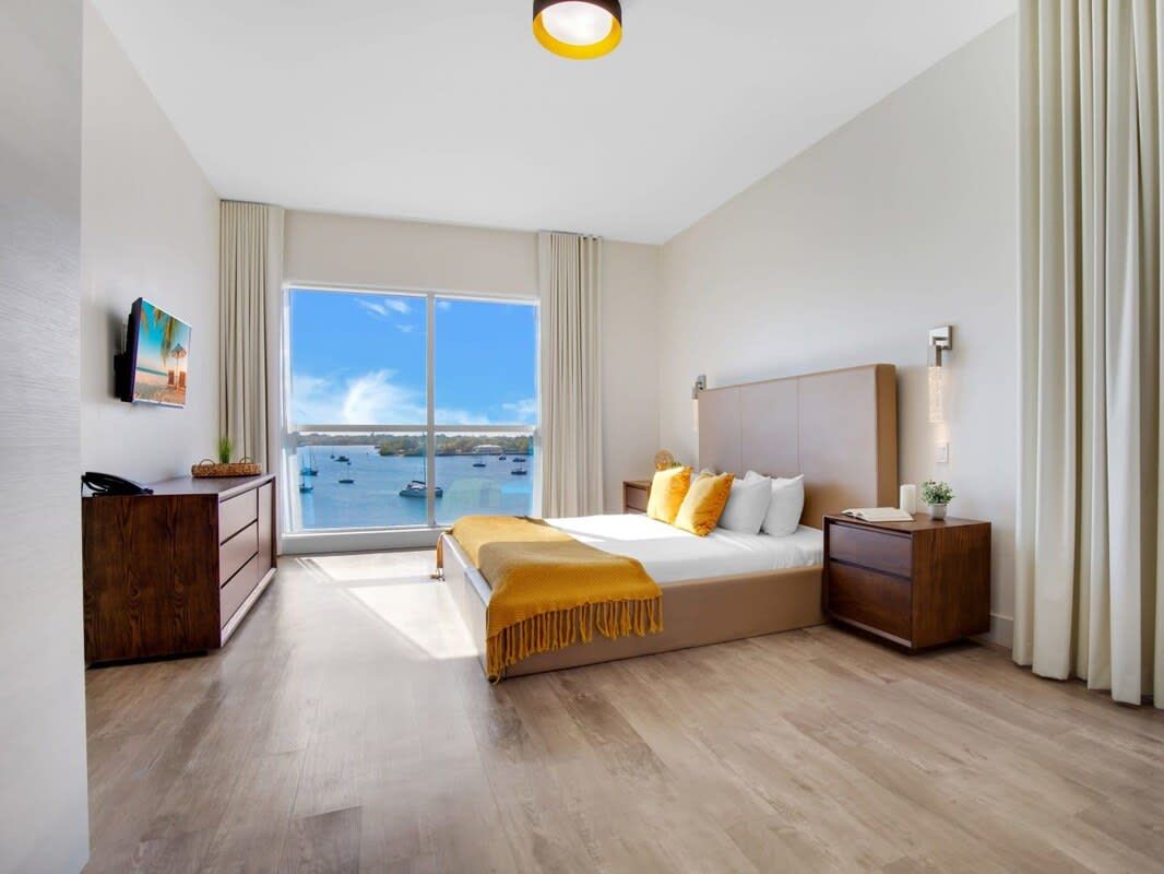 Et moderne hotelværelse med en stor seng, et skrivebord, et natbord og havudsigt.