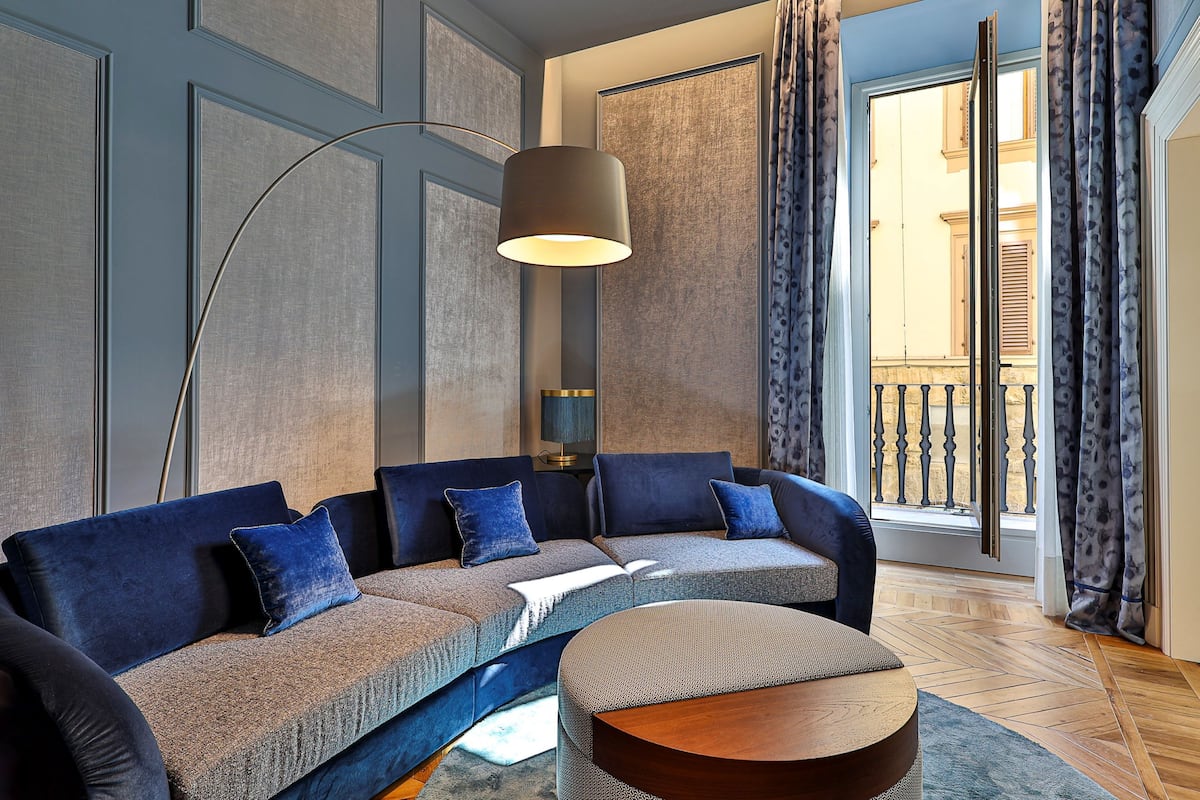 A modern living room with a sectional sofa, a round coffee table, and a floor lamp.