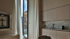 A modern kitchen with a marble backsplash, a built-in sink, and a coffee machine. - Palazzo Signoria Luxury Apartments (Florence)
