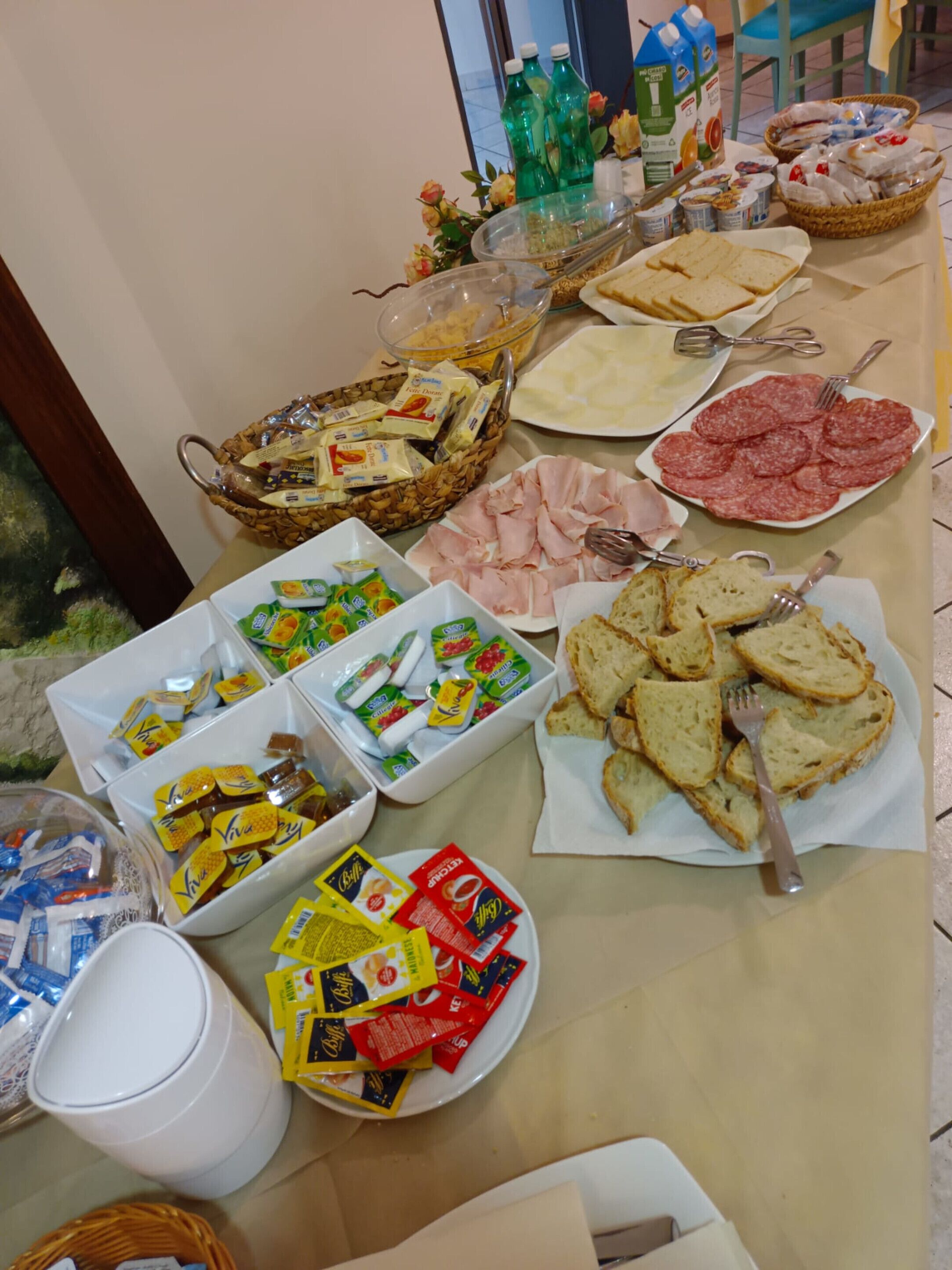 Ein Buffet mit verschiedenen Speisen, darunter Brot, Käse, Fleisch und Soßen.