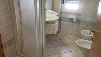A bathroom with a toilet, bidet, and sink.