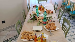 Een eettafel gedekt met borden eten, flessen en glazen.