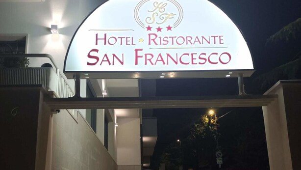 Een goed verlichte ingang van Hotel Ristorante San Francesco, met een duidelijk bord boven de deur.