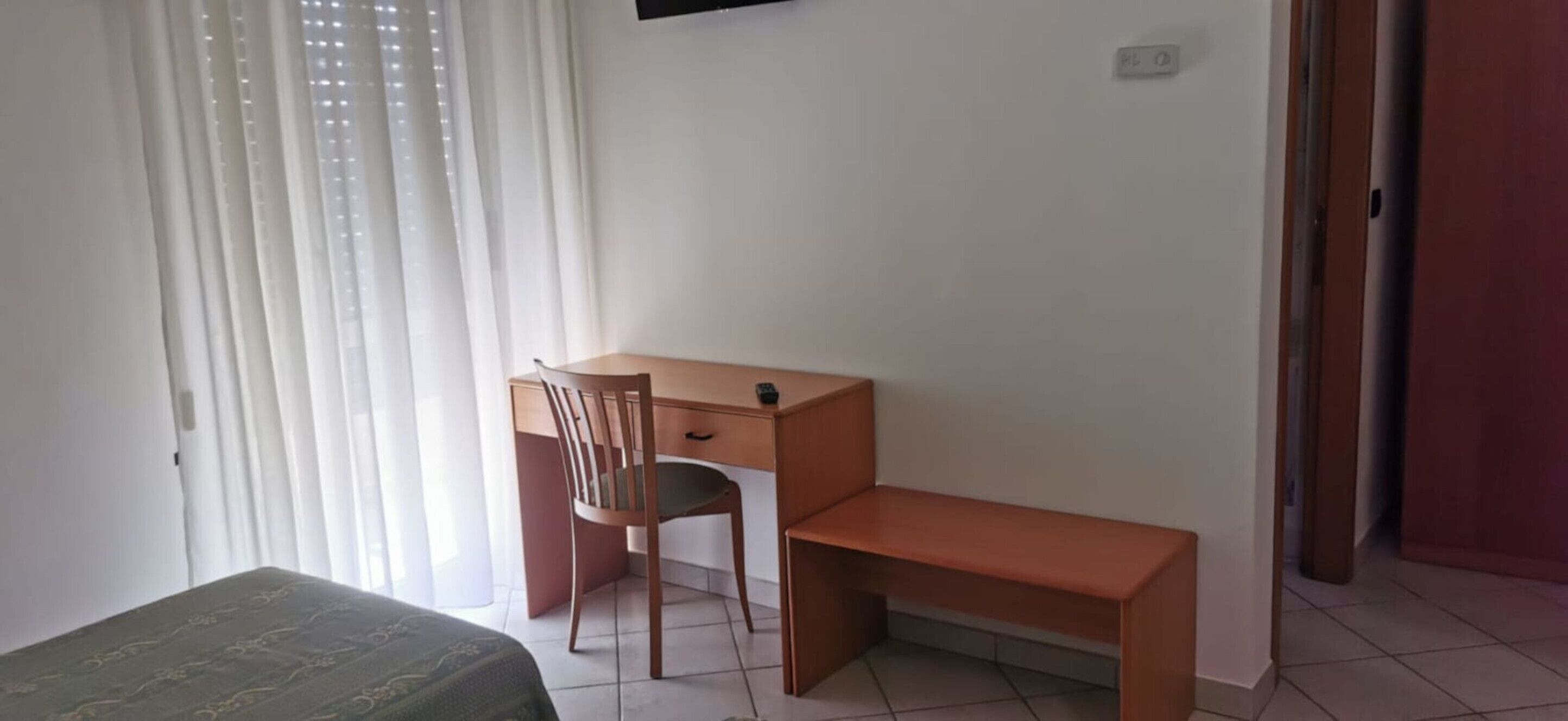 Un dormitorio con cama, escritorio y silla.