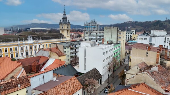 A cityscape with a prominent church tower, modern buildings, and a mix of residential and commercial structures. - Siesta Boutique Smart Suites (Cluj-Napoca)