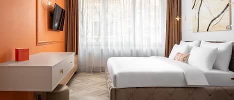 Un dormitorio con cama, escritorio, silla, televisor y un cuadro en la pared.