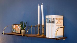 Una estantería con libros, velas y un marco con una fotografía.