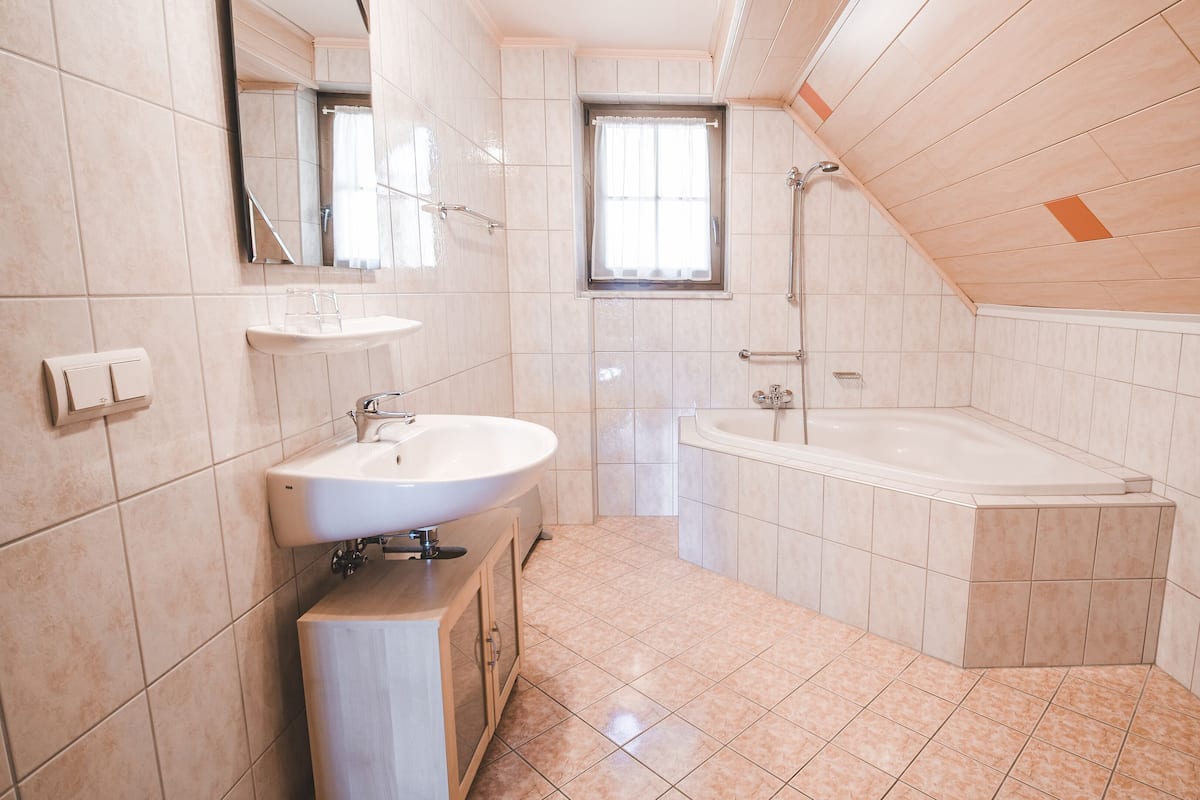 Un baño moderno con lavamanos, espejo y bañera.