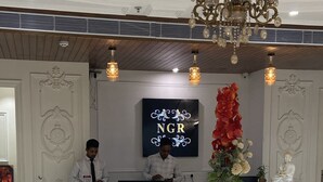 Una recepción con diseño moderno, un candelabro y un jarrón decorativo.