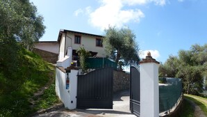 A gated entrance to a house with a driveway leading to the front door. - Ferienhaus mit Meerblick, Terrasse, Wlan, Parkplatz (Toscana)