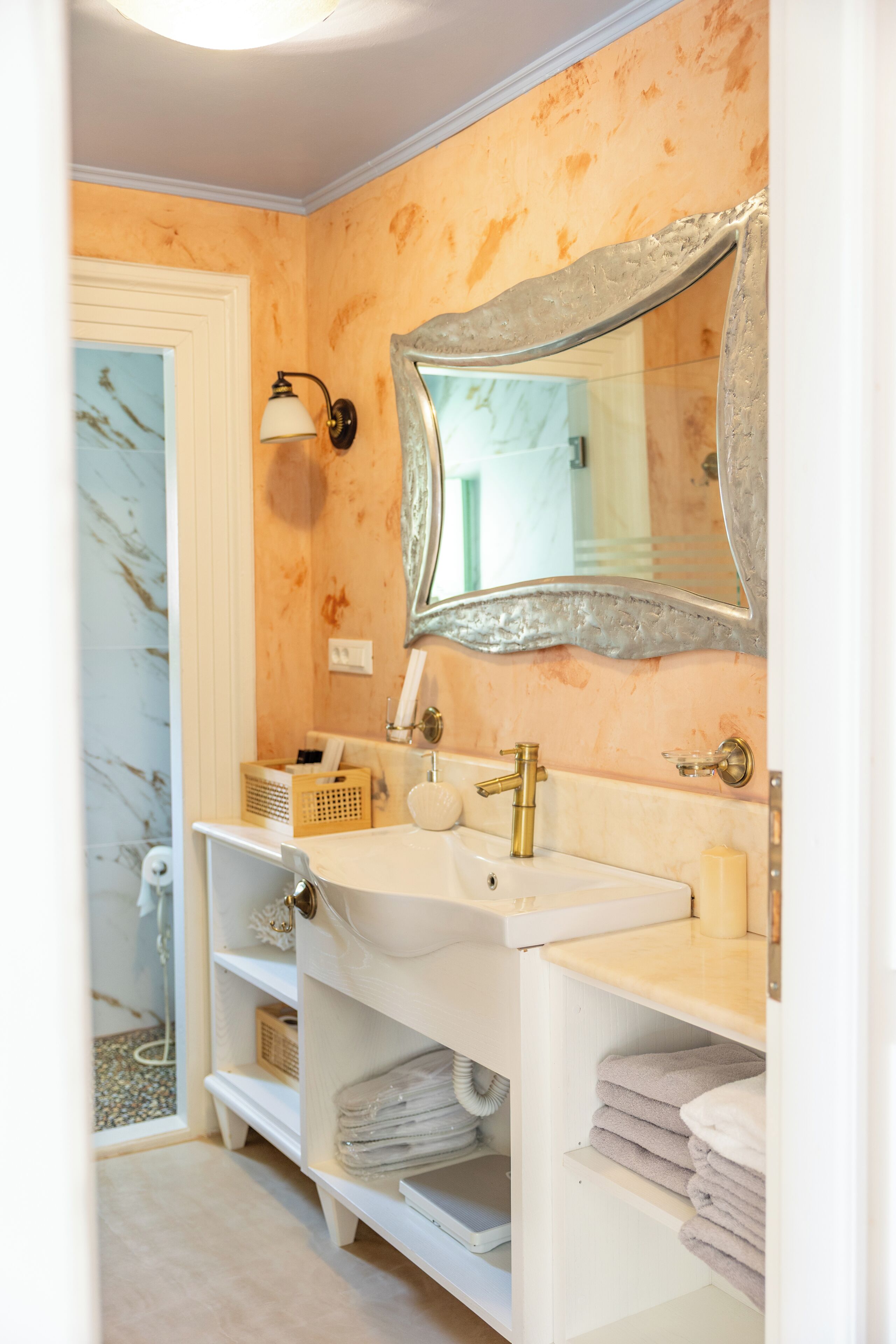 A bathroom with a white vanity, a large mirror, and a towel rack.