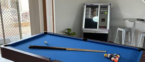 Een biljart met ballen, een lijst en een biljart met een digitaal scorebord.