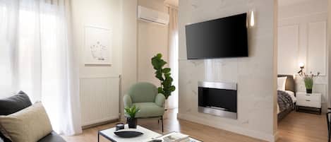 A modern living room with a sofa, coffee table, and a flat-screen TV mounted on the wall.
