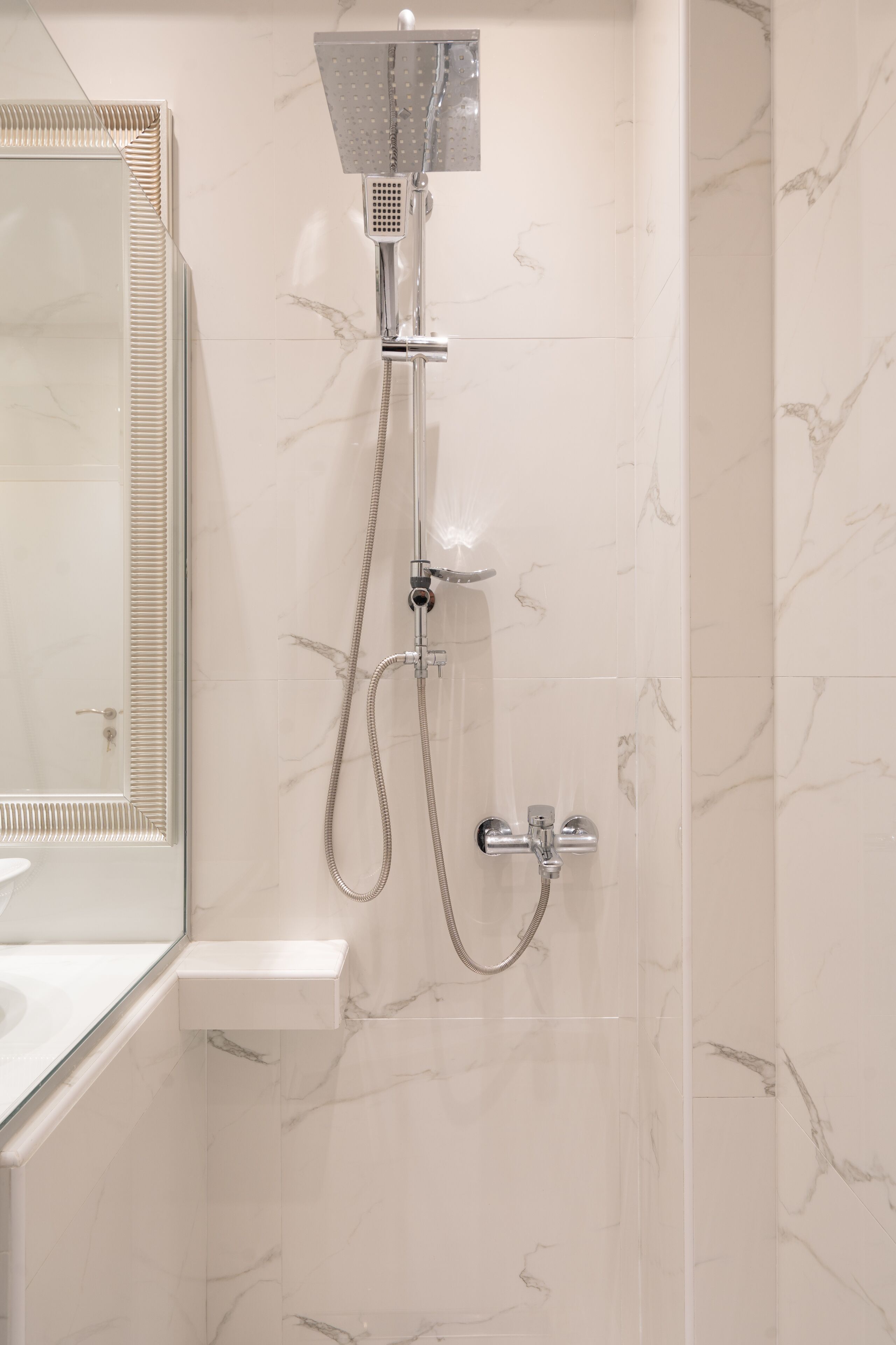 A bathroom with a shower, a sink, and a mirror.