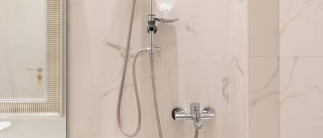 A bathroom with a shower, a sink, and a mirror.