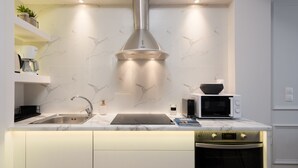 A modern kitchen with a stainless steel range hood, a built-in microwave, and a sleek countertop.
