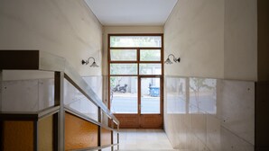 A staircase leading to a door with a view of a street outside.