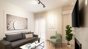 A modern living room with a grey sofa, a green armchair, a coffee table, and a fireplace.