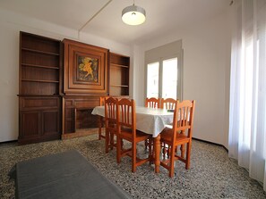 Un espace repas comprenant une table, des chaises, un banc, un meuble en bois et un tableau.