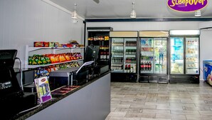 A clean, modern interior with a counter, snack shelves, and beverage refrigerators. - SleepOver Upington (Upington)