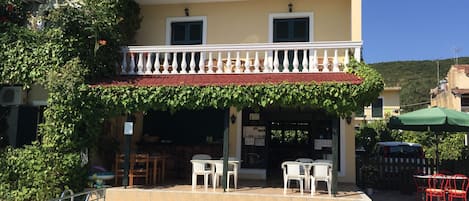 A building with a pool, outdoor seating, and a covered patio area.