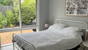 A bedroom with a bed, a ceiling fan, a window, and a framed picture on the wall. - Ronny's Tootgarook. (Tootgarook)