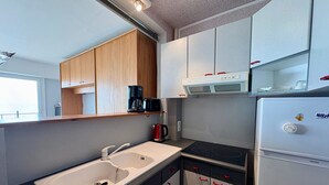 A compact kitchen with a sink, stove, and a refrigerator. - Comfortable Studio for 3 in Saint Jean de Monts, Near Beach (Saint-Jean-de-Monts)