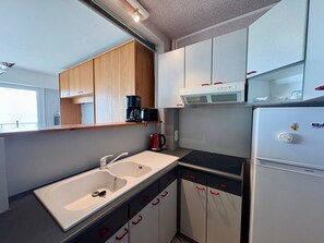A compact kitchen with a sink, stove, and a refrigerator.