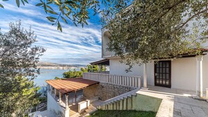 A coastal property with a terrace overlooking the sea, a stone staircase leading to the entrance, and a view of the distant landscape. - 4 bedroom nice home in Okrug Donji (Okrug Donji)