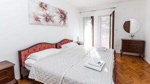 A bedroom with a double bed, a wooden dresser, a nightstand, a mirror, and a painting on the wall. - 4 bedroom nice home in Okrug Donji (Okrug Donji)