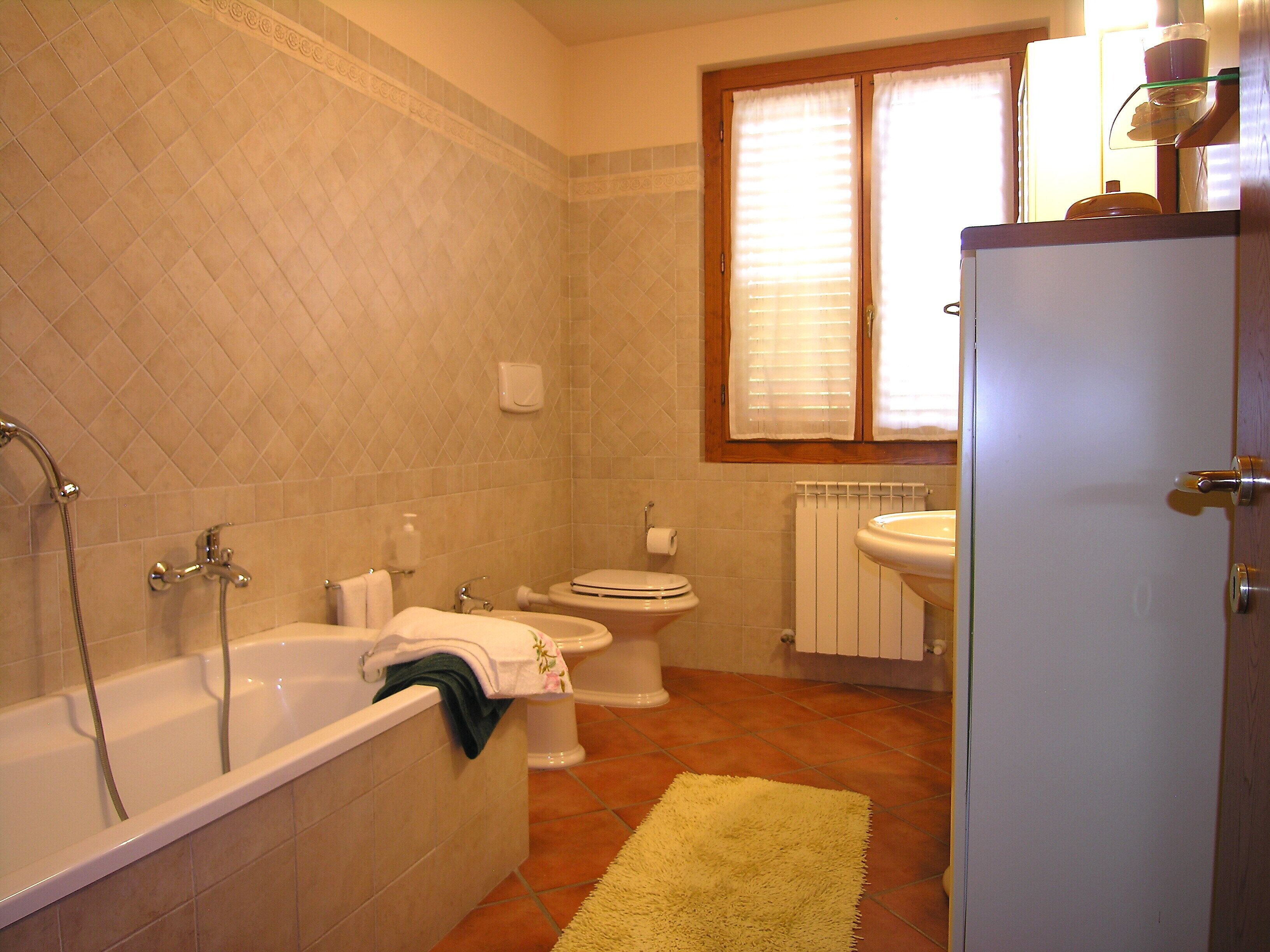 A bathroom with a bathtub, toilet, and sink.