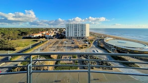 Un paisaje urbano costero con un edificio blanco destacado, una playa y una glorieta.