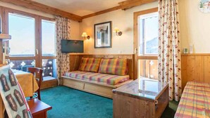 A cozy room with a sofa, a television, and a wooden chest.