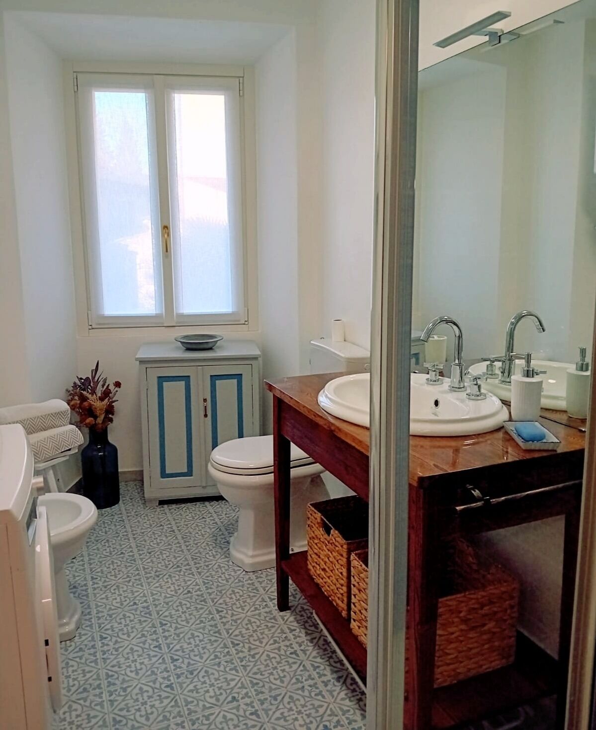Een badkamer met toilet, wastafel en raam.