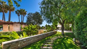 A well-maintained garden with a stone pathway, lush greenery, and palm trees. - 3680 Villa Monica by Perle di Puglia (Polignano a Mare)