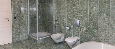 A bathroom with a shower, toilet, and bathtub.