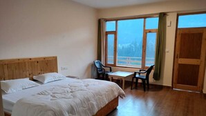 A bedroom with a wooden bed, a desk, two chairs, and large windows with curtains. - Private Room in Manali, Mountain and River view Near Manali-4 (Bashisht)