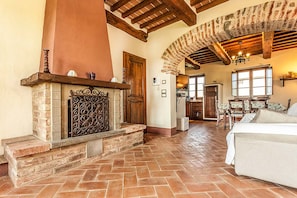 Un salón amplio con chimenea, vigas de madera y zona de comedor.